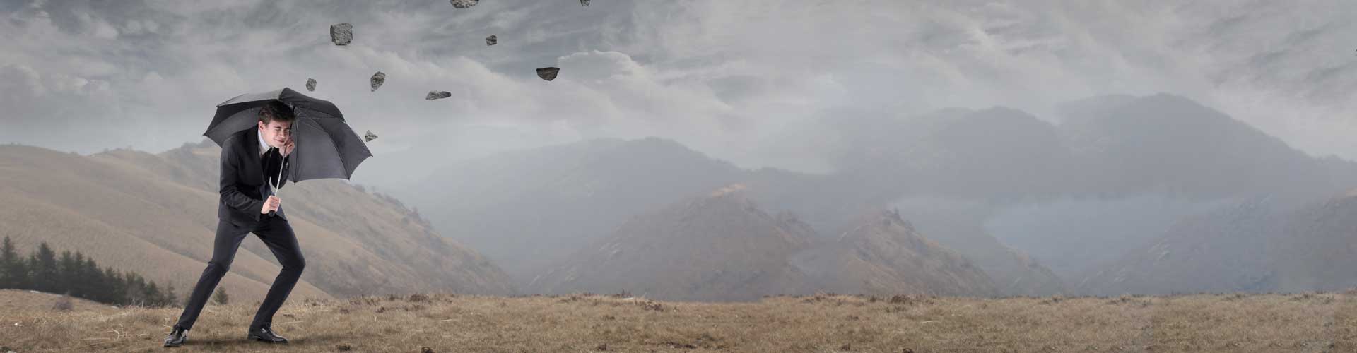 man holding umbrella in storm